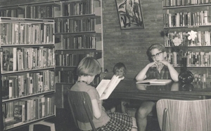 Een foto van de bibliotheek genomen rond 1967. De boekencollectie was toen nog ondergebracht in het dorpshuis. Op de foto zitten Ali Meijer, Henk Heijkoop (rechts) en Tsjikke Meijer (achter) met de neus in de boeken. FOTO PRIVÉ-ARCHIEF ALI BRONGER-MEIJER