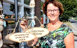 Rennie Steensma bij haar Bildtse bordjesmolen voor het verenigingshuis De Spitsroeden. FOTO JAN SPOELSTRA