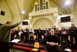Het Christelijk Bildts Mannenkoor repeteert voor de jubileumuitvoering onder leiding van dirigent Sieb Leenstra. FOTO NIELS WESTRA
